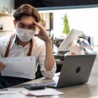 asian cafe owner man look frustrated to bills